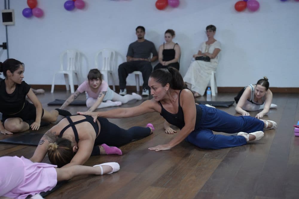 Turma adulta alongando no chão com a professora